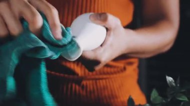 close - up of a hand holding a white bottle with a liquid