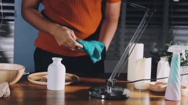 woman cleaning table in the kitchen with spray and detergent