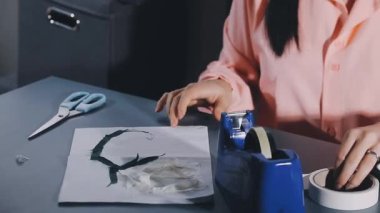 female hand holding a white paper with a pen