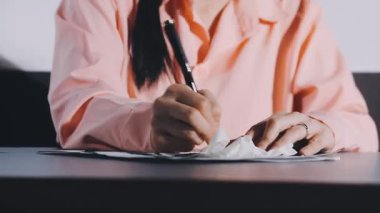 woman writing on a paper in a cafe