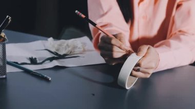 artist paints in a white shirt with a brush.