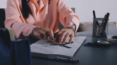 young woman working in a modern home office, using a digital tablet.