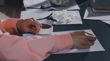 woman writing a white pencil on a paper sheet