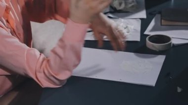 female artist in white shirt working in studio