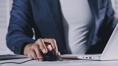 İş kadını ofiste dizüstü bilgisayar kullanıyor.