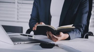 young asian man reading a book in the room