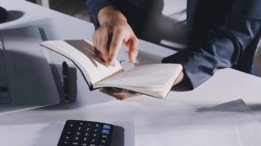 İş adamı ofiste kitap okuyor.