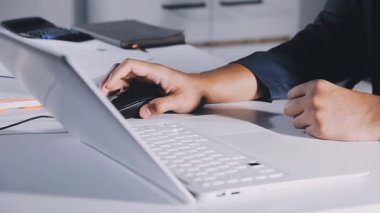 Ofiste bilgisayarla çalışan genç bir işadamı..