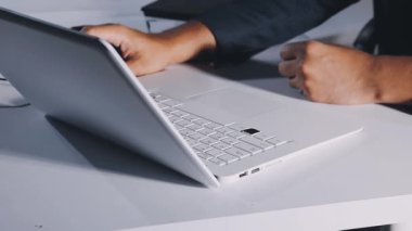 İşadamı ofiste dizüstü bilgisayarla çalışıyor.