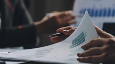 businessman working at laptop with financial graph and calculator at desk in the office