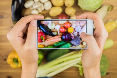 Taze organik sebze fotoğraf rustik ahşap masa, üstten görünüm çekici. Düz Fotoğraf çekme eller Close-up yörede yetiştirilen doğal vegan gıda yatıyordu