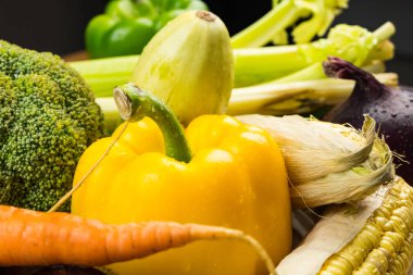 Rustik ahşap masa, taze organik sebze yakın çekim. Yörede yetiştirilen dolmalık biber, Mısır ve diğer doğal vegan gıda masaya döşeme