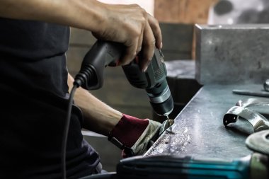 Erkek demir ustası ortaçağ zırh takım elbise bir parçası oldu. Makine donanım bir atölyede metal parçalar elektrik ile tedavi adam eller matkap