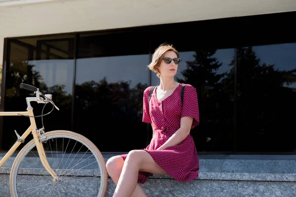 Wanita Elegan Dalam Gaun Polka Dot Duduk Dekat Sepeda Retro — Stok Foto