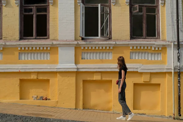 Gadis Berjalan Sepanjang Bangunan Kuning Tua — Stok Foto