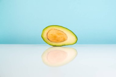 Beyaz masa üzerinde yarım avokado meyve. Parlak studio arka planda alligator armut parçasının minimalist görüntü