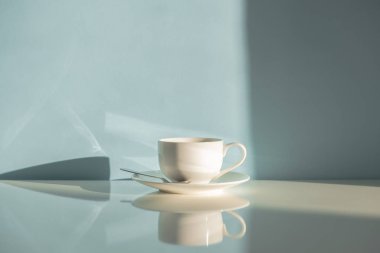 Buğulaması fincan kakao yeşil arka planda doğal güneş ışığı üzerinde kahve. Sıcak espresso içki soluk mavi-yeşil masa ve duvar soyut fotoğraf