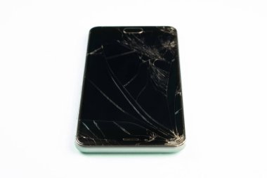Cep telefonu ile kırık siyah perde, üstten görünüm. Sıkıntılı hasarlı akıllı telefon uçuk yeşil arka plana, sığ derinlik-in tarla