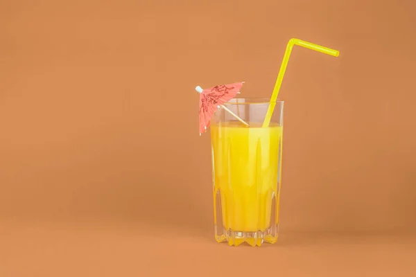 赤の背景にオレンジ カクテルを飲む 明るいミニマルな環境で柑橘類のジュース グラスのイメージ — ストック写真
