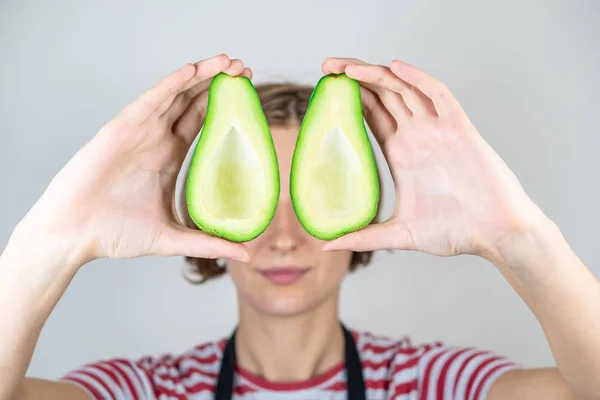 Fersk Moden Avokado Kvinners Hender Kvinnelig Ansikt Gjemt Bak Halvdeler – stockfoto