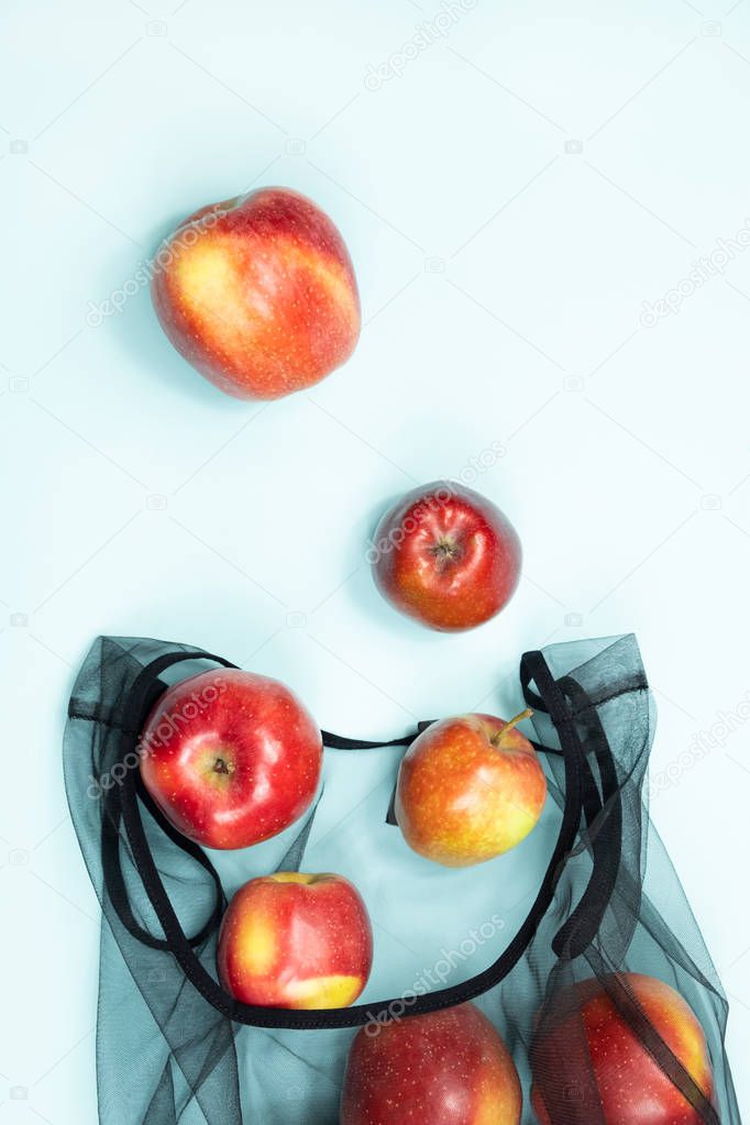 Top view of apples in a reusable string bag. Sustainable eco packaging concept: shopping for groceries with a multi-use bag to reduce ecological footprint