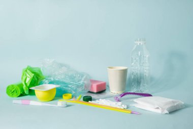 Plastik atık kavramı: tek çeşitli her gün, en iyi görünümü atılan nesneleri kullanın. Plastik şişe, hijyen öğeleri ve bir everage kişinin ekolojik ayak izi resmeden plastik ambalaj.