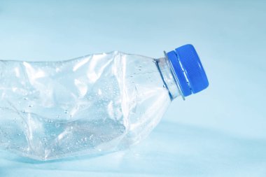 Plastik atık kavramı: mavi arka plan buruşuk su şişe atılır, ayrıntılı görünümü. Yakın çekim görünümünü atılmış bir dış görev Tek Kişilik Kullanım plastik şişe aşırı kirlilik tasvir