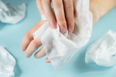 Mantıksız plastik kirliliği kavramı: ıslak mendil aşırı kullanımı. Yakın çekim görünümü nemli kurcalayarak temizlenmiş eller