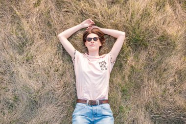 Genç kadın çimlerin üzerinde baharın tadını çıkarıyor.