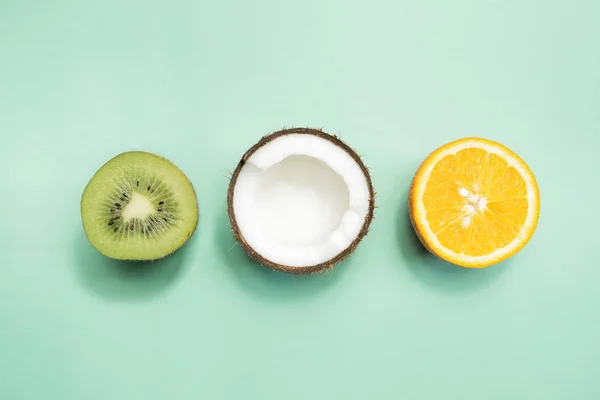 Kiwi frutas, coco e laranja sobre fundo verde — Fotografia de Stock