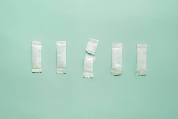 Stick de sare sau zahăr într-un rând de bețe de zahăr în fundal verde, concept de epuizare emoțională — Fotografie, imagine de stoc
