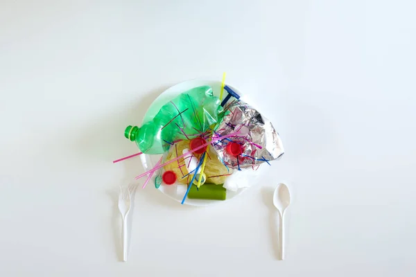 Πλαστικά σκουπίδια σε ένα πιάτο. — Φωτογραφία Αρχείου