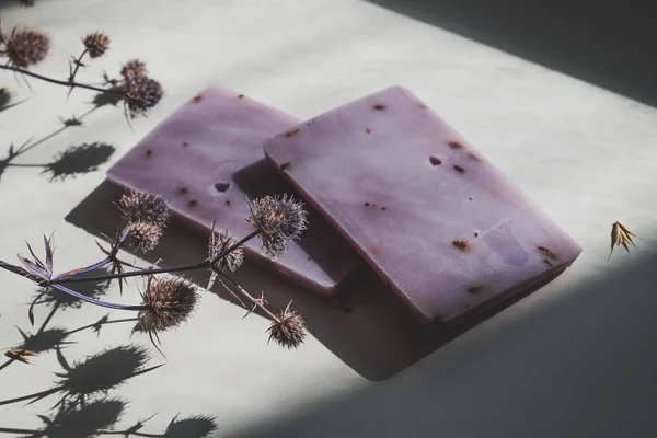 自然光の中で乾燥した花と自然なラベンダー石鹸バー. ロイヤリティフリーのストック画像