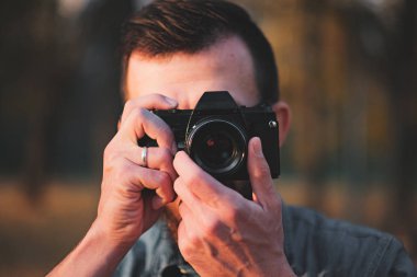 Eski bir kamerayla fotoğraf çeken bir adam..