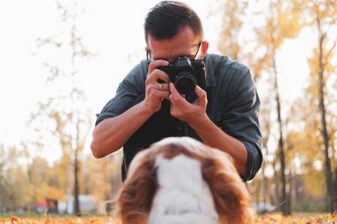 Parkta köpeğinin fotoğrafını çeken bir adam.. 