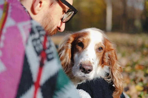 Porträtt av en ung man och cocker spaniel på hösten bakgrund. — Stockfoto