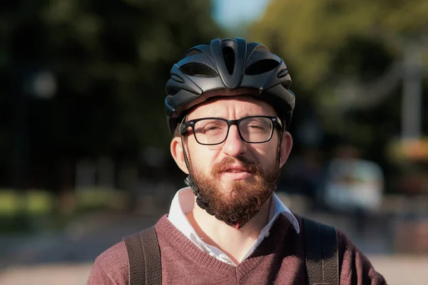 Portrait of a millennial commuter in a bicycle helmet. Safe cycling in the city, going to work on a bike, modern urban lifestyle image