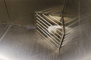 Metal çubuklardan oluşan bir kafesin arkasında hareket dedektörü var. Kafes kiremitlere vidalanır ve doğru açıyla birleşir. İzler ve zayıf örümcek ağları yaşını gösteriyor. Korunan eşyalar güvenlik ve düzeni gösteriyor..