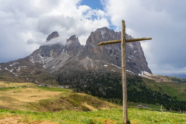Cross on the background of Sassolungo. Dolomites. Italy.