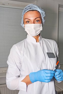 Dermatolog güzellik uzmanı hastasını ameliyat maskesi ile bekler