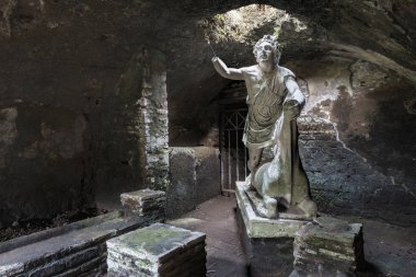 Statue of the god Mithras killing a bull in the thermal s mithraeum in archaeological excavations of Antica Ostia clipart