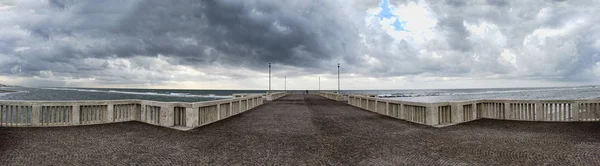 素晴らしい海の景色を見ているだけで男雲の距離で雨の中の準備ができてで覆われて荒れる海を風光明媚な空に桟橋からパノラマ — ストック写真