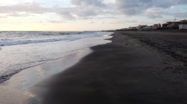 Kıyıya yakın kum üzerinde bulutlu bir günde yürüyüş