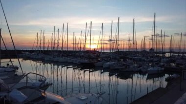 Ostia Lido Roma, İtalya - 03 Şubat 2019: Doğal zaman atlamalı günbatımı Marina'da demirleyen birçok Yelkenli ile Ostia rüzgar ve düşündüren bir atmosfer ile sarsıldı