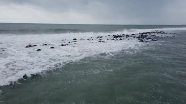 Dalgalar kayalar üzerinde çökmesi ile fırtınaya ve köpüklü deniz