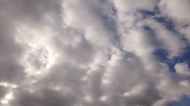 Beyaz sirokümülüs bulutları hızlandırılmış ışık efektleriyle gökyüzünde süzülen gölgeler