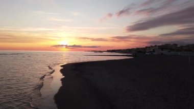 Roma 'nın Ostia Lido bölgesindeki güzel gün batımı sakin deniz ve pastel renkli alacakaranlıkla deniz suyuna yansıyan güneş ışığı muhteşem gökyüzü ve rahatlatıcı atmosferi ile birlikte.