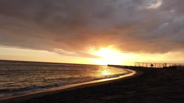 オスティア リドのローマ海岸での美しい時間の経過日没 美しい太陽の反射で曇った空に包まれた桟橋と人々のシルエット — ストック動画