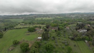 Tarlaları, ekili tarlaları ve tepeler ve yeşil vadiler arasında çayırları ve meyve ağaçları olan kır evleri olan manzaralı Havacılık manzarası