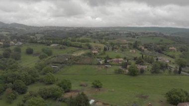Yeşil vadiler ve tepeler ve orman, çiftlik evleri ve bulutlu bir gökyüzünde meyve ağaçları ve Soratte dağın silueti ile ekili alanlar ile İtalya kırsal Awesome havadan görünümü
